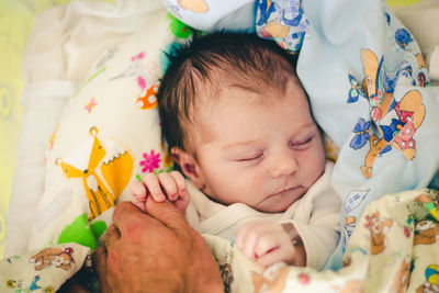 High angle view of cute baby boy sleeping on bed at home