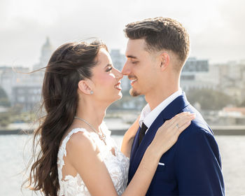 Side view of couple standing against sky