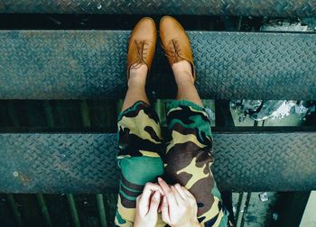 Upside down image of woman wearing shoes while sitting on steps