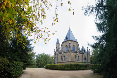 View of trees and building against sky