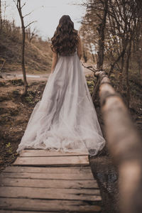 Rear view of woman standing in forest