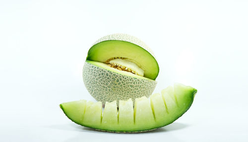 Close-up of green fruit against white background