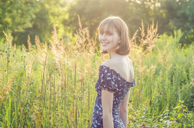 Portrait of smiling woman standing on field