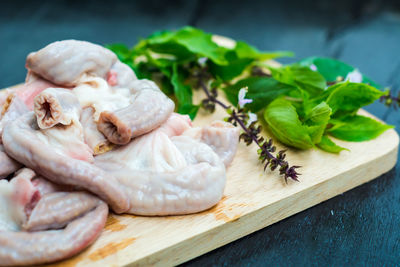 Close-up of meat and herbs on cutting board over table