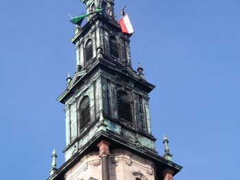 Low angle view of clock tower against blue sky