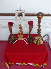 Close-up of cross on table against wall