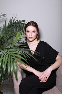 Portrait of young woman standing against white background