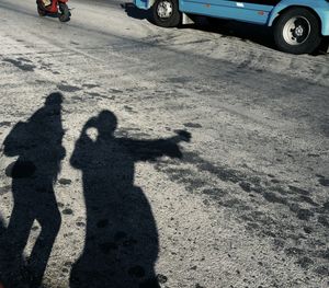 High angle view of people shadow on sand