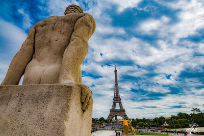 Low angle view of statue of building against cloudy sky