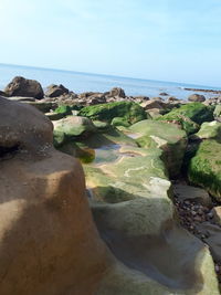 Rocks on beach against sky