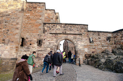 Group of people walking in front of historical building