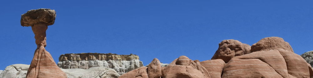 Low angle view of rock formation against clear blue sky