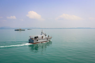 Fishing boat sailing in sea against sky