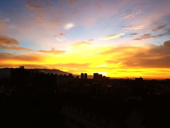 Silhouette buildings against sky during sunset