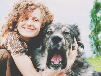 Portrait of happy young woman embracing caucasian shepherd dog