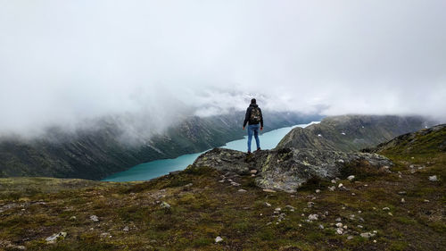 Rear view of man on mountain against sky