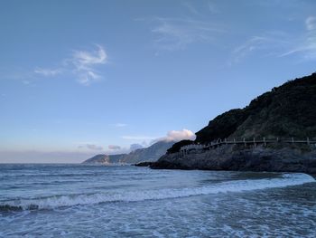 Scenic view of sea and mountains against sky