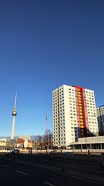 Modern buildings in city against clear blue sky