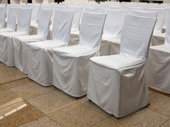 Many festive white coated chairs in a hall