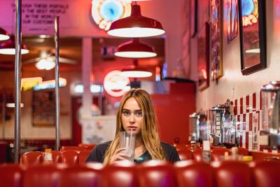 Young woman sitting in illuminated room