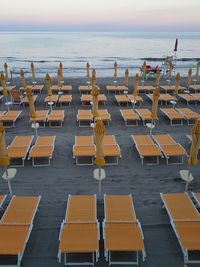 Chairs on beach against sky