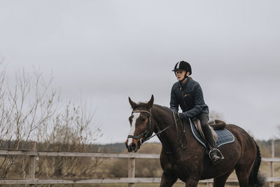 View of girl horseback riding