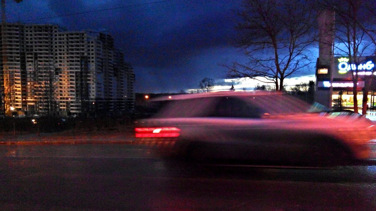 illuminated, building exterior, night, car, city, architecture, transportation, land vehicle, street, built structure, road, mode of transport, sky, city street, traffic, tree, long exposure, street light, city life, dusk