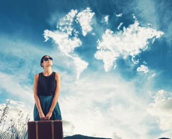 Low angle view of woman standing against sky