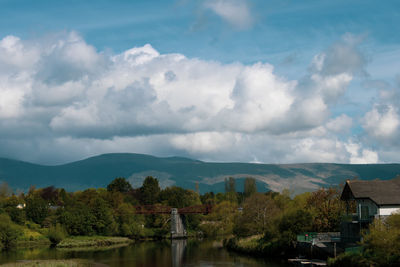 Scenic view of lake by buildings against sky