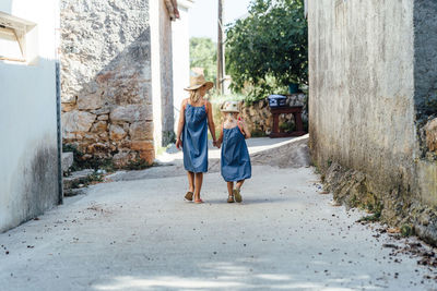 Rear view of women walking on footpath