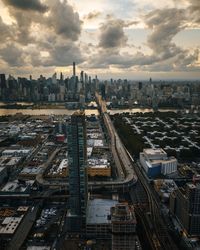 High angle view of city buildings against cloudy sky