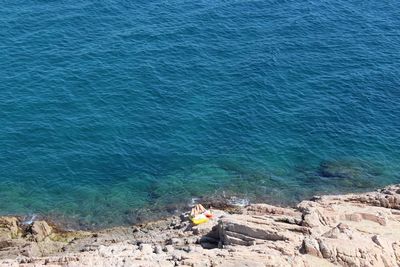 High angle view of man sitting by sea