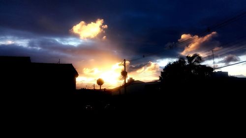 Silhouette houses against sky at night