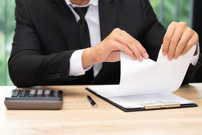 Midsection of man using laptop on table