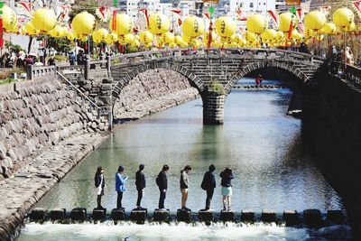 People walking on bridge over canal