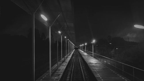 Illuminated railroad tracks at night