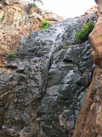 Low angle view of waterfall on cliff
