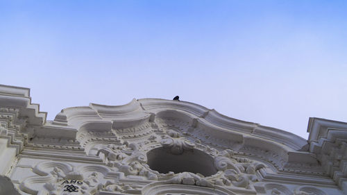 Low angle view of sculptures on building against sky