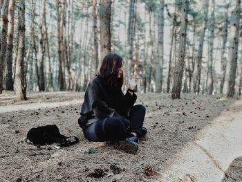 Woman sitting on land in forest