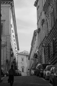 Man walking on street amidst buildings