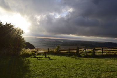 Scenic view of grassy field against cloudy sky