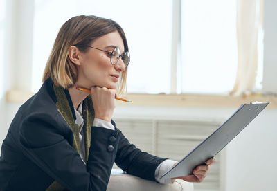 Side view of young woman using mobile phone