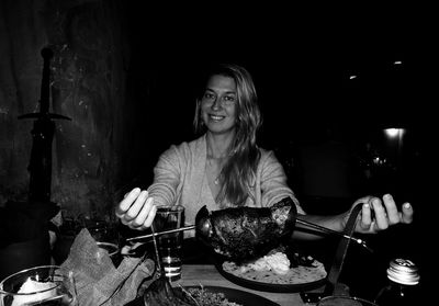 Woman about to eat a roast in a restaurant, in black and white