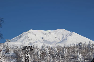 Scenic view of snowcapped mountains against clear blue sky