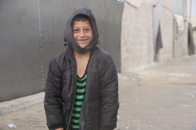 Cute syrian child in a refugee camp in the rain.