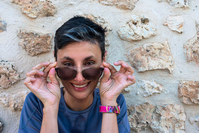 Mature woman, smiling, looking over sunglasses