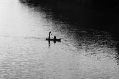 High angle view of silhouette men on boat sailing in river