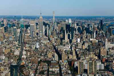 Empire state building in city against clear sky