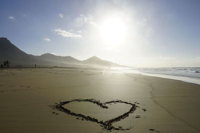 Heart shape on beach against sky