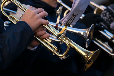 Midsection of musicians playing trumpets during event